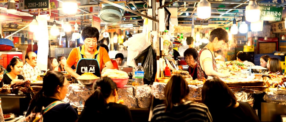 Gwangjang Market culinary experience Gwangjang Market food stalls with vendors preparing traditional dishes